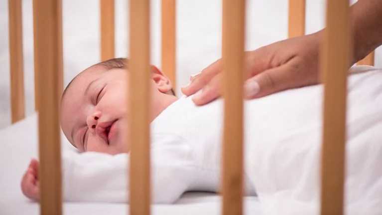 Peaceful newborn sleeping in a crib with soft lighting